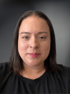 Professional photo of a female with short dark brown hair, smiling, and wearing a black shirt