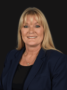 Professional photo of Kristie in business professional attire. Kristie is a middle-aged woman with blonde hair.