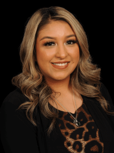 Professional photo of a young female recruiter with black and blonde hair wearing a leopard blouse and black cardigan