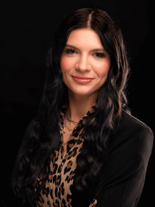 Professional photo of Gabby. She is a young woman with dark hair. She is dressed in business professional clothes. 