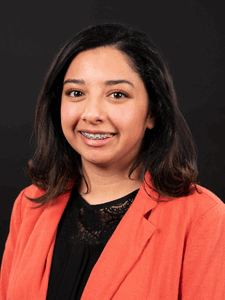 Professional photo of Michealle. Michealle is a young woman with dark colored hair. She is dressed in business professional attire.