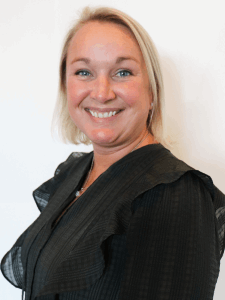 Professional photo of a female professional recruiter with short blonde hair wearing a black long-sleeve dress