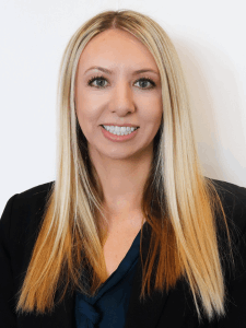 Professional photo of a female accounting and finance recruiter with blonde hair wearing a navy button-down top and a black blazer