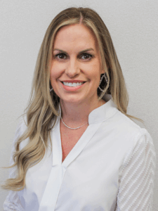 Professional photo of a sales manager with blonde hair wearing a white button-down top