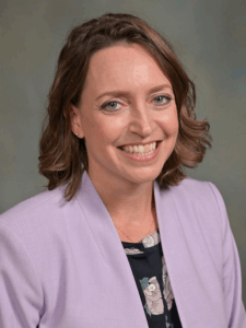 Professional photo of a female Dallas/Fort Worth Developer Representative with short brown hair wearing a black top and light purple blazer