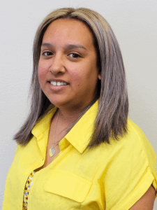 Professional photo of a female front desk receptionist with a yellow top