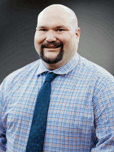 Professional photo of a male Light Industrial and Skilled Trades recruiter, bald with beard wearing a button down shirt