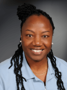 Professional photo of a female Office and Administrative recruiter with dark hair wearing a blue collared shirt