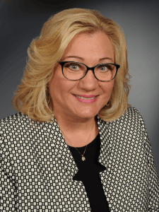 Professional photo of a female Accounts Receivable Supervisor with short blonde hair and a black and white blazer and glasses