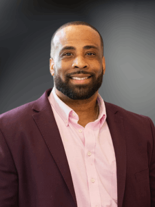 Professional photo of a male Business Development and Sales Rep with a pink shirt and maroon blazer